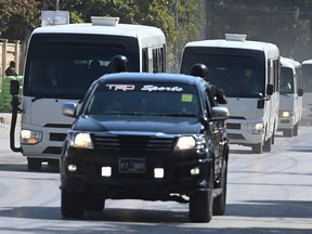 Security personnel escort a convoy carrying Australian and Pakistani cricketers as they arrive at the Rawalpindi Cricket Stadium to attend practice session in Rawalpindi on March 1, 2022, ahead of the first cricket Test match between Pakistan and Australia.