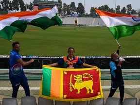 Cricket fans display the flags of India (left, right) and Sri Lanka (centre) before a cricket Test match between India and Sri Lanka at the Punjab Cricket Association (PCA) Stadium in Mohali on March 3, 2022.
