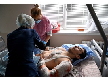 Medical workers provide medical assistance to an Ukrainian serviceman wounded during the fighting with Russian troops near the Ukrainian capital, in a hospital in Kyiv on March 4, 2022.