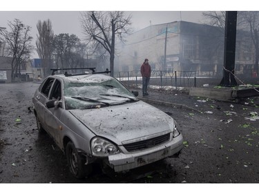 A man looks over rubble and a damaged vehicle across the street from the Kyiv TV Tower on March 2, 2022 in Kyiv, Ukraine.