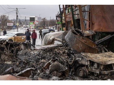 People walk past a destroyed Russian military vehicle at a frontline position on March 3, 2022 in Irpin, Ukraine. Russia continues assault on Ukraine's major cities, including the capital Kyiv, a week after launching a large-scale invasion of the country.