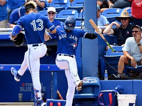 Toronto Blue Jays designated hitter Lourdes Gurriel Jr. (13) celebrates with right fielder baseman Cavan Biggio (8) after hitting a solo home run in the second inning of the game against the Detroit Tigers during spring training at TD Ballpark on Thursday.