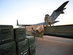 Servicemen of Ukrainian Military Forces load a flat bed truck as boxes of U.S.-made FIM-92 Stinger missiles (L), a man-portable air-defence system (MANPADS), that operates as an infrared homing surface-to-air missile (SAM), are stacked after being shipped in to Boryspil Airport in Kyiv on February 13, 2022. SERGEI SUPINSKY/AFP via Getty Images)