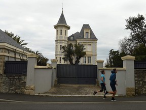People jog by the "Altamira" villa in Biarritz south-western France, on Feb. 27, 2022.