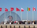 People gather during a flag-raising ceremony of the  newly-qualified countries for the 2022 World Cup in the Qatari capital Doha, on March 30, 2022. Traffic police nervously watched a World Cup crowd make a mark in Qatar's capital as FIFA set the scene for even bigger gatherings at the event by announcing that 800,000 tickets have already been sold. 