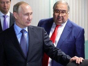 In this file photo taken on July 14, 2017, Russian President Vladimir Putin and founder of USM Holdings Alisher Usmanov look on at the control centre of the new workshop producing hot briquetted iron at Lebedinsky Mining and Processing Combine (Metalloinvest MC LLC) in the Belgorod Region.