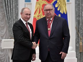 Russian President Vladimir Putin, left, shakes hands with Russian businessman and founder of USM Holdings Alisher Usmanov during an awarding ceremony at the Kremlin in Moscow, Russia, Nov. 27, 2018.