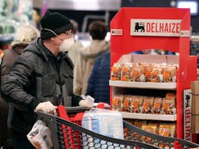Belgian shoppers are seen inside a Delhaize supermarket in Brussels, Belgium, March 18, 2020.