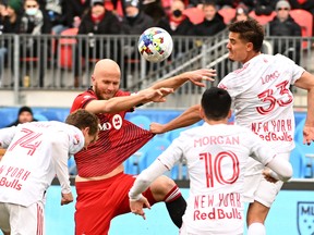 Toronto FC's Michael Bradley contests a header with New York Red Bulls' Aaron Long  and Tom Barlow during the first half at BMO Field on Saturday, March 5, 2022.