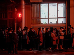 People line up near a nucleic acid testing site outside a hospital during mass testing for COVID-19 amid the pandemic, in Shanghai, China, March 27, 2022.