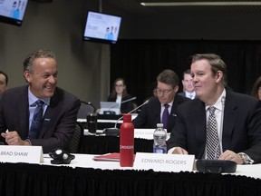 Edward Rogers, right, chairman of Rogers Communications, and Brad Shaw, chairman and CEO of Shaw Communications, chat before the start of the CRTC hearing looking into the merge of the two communication companies in Gatineau, Quebec, on November 22, 2021.