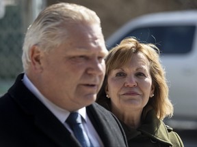 Ontario Health Minister Christine Elliott looks over at Premier Doug Ford as she attends an announcement in Toronto, Friday, March 4, 2022, confirming that she will not be seeking re-election in June.