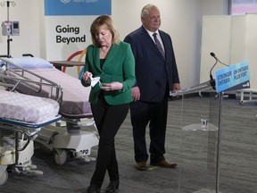 Ontario Health Minister Christine Elliott turns from the microphone after taking a question from the media, as Premier Doug Ford looks on, during a health-care  announcement in Brampton March 15, 2022.