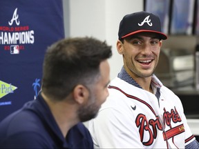 Braves baseball team newly acquired all-star first baseman Matt Olson (right) smiles as he is introduced by Braves GM Alex Anthopoulos yesterday. The Braves signed Olson to a $168-million, eight-year contract.