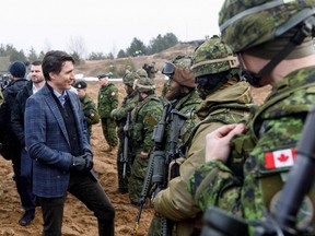 Prime Minister Justin Trudeau talks with soldiers during a visit of the Adazi military base, northeast of Riga, Latvia, on March 8, 2022.