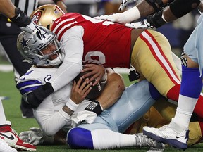 Samson Ebukam and Nick Bosa of the San Francisco 49ers sack Dak Prescott of the Dallas Cowboys during the NFC Wild Card Playoff game at AT&T Stadium on January 16, 2022 in Arlington, Texas.