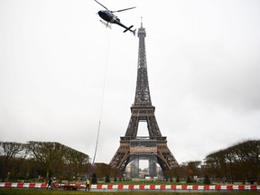 This photograph taken in Paris on March 15, 2022 shows a new antenna installed by a Eurocopter AS355N Ecureuil 2 at the top of the Eiffel Tower.