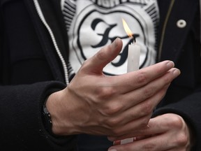 A fan of Foo Fighters holds a lit candle while standing outside Casa Medina Hotel where the band's drummer Taylor Hawkins was found dead on March 26, 2022 in Bogota, Colombia.