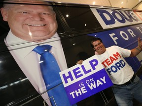 A Doug Ford supporter poses in front of the Ford election bus inside the Toronto Congress Centre before the final vote was cast in the Ontario election on June 7, 2018.