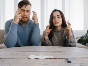 Hopeful couple checking a pregnancy test.