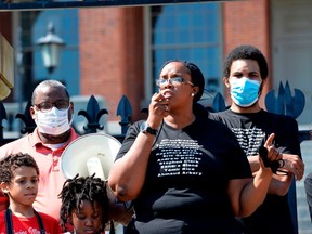 Protesters, including Eric Garner Jr., (R) gather at the State House as Monica Cannon-Grant(C), speaks during a Juneteenth protest and march in honor of Rayshard Brooks and other victims of Police Violence in Boston, Massachusetts on June 22, 2020.