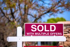 Sold with multiple offers real estate sign.