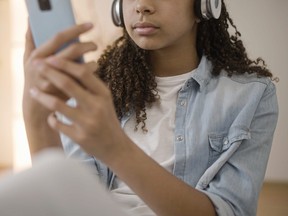 Girl wearing headset using smartphone app.
