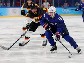 Nick Abruzzese of Team USA holds off Konrad Abeltshauser of Germany during the Olympic men's hockey tournament in Beijing last month.