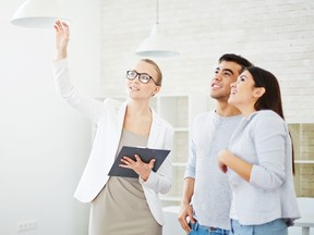 A realtor shows a couple a home.