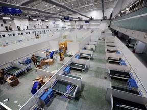 Workers set up beds to convert an exhibition centre into a makeshift hospital, following the coronavirus disease (COVID-19) outbreak in Changchun, Jilin province, China March 12, 2022.