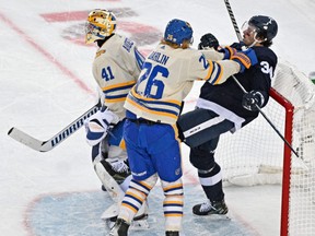 Buffalo Sabres defenceman Rasmus Dahlin (26) knocks Toronto Maple Leafs forward Auston Matthews (34) into the goal behind goalie Craig Anderson (41) in the 2022 Heritage Classic ice hockey game at Tim Hortons Field in Hamilton on March 13, 2022.