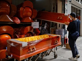 Workers move coffins as mortuaries run short of coffins amid lockdown during the coronavirus pandemic in Hong Kong, China, March 16, 2022.