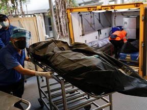 Workers move a corpse at a mortuary, following the COVID-19 outbreak in Hong Kong, China, Saturday, March 5, 2022.