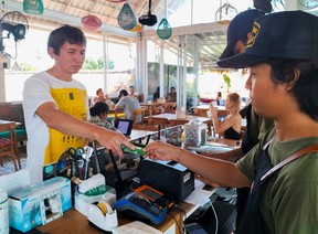 Senator Ruslan, ein 43-jähriger Russe, der auf Bali Urlaub macht, versucht, eine Karte seines russischen Bankkontos zu verwenden, um sein Mittagessen in einem Café in Canggu, Regentschaft Badung, Bali, Indonesien, am 9. März 2022 zu bezahlen.