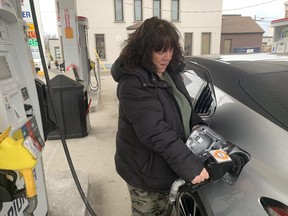 Jennifer Quildon pumps gas into her Toyota on Wednesday, March 30, 2022. She's expecting to receive her hybrid version of the same car on April 1.