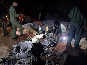 People work around what Pakistani security sources say is the remains of a missile fired into Pakistan from India, near Mian Channu, Pakistan, Wednesday, March 9, 2022.