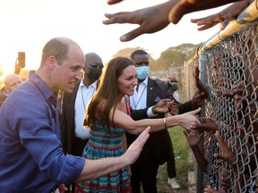 Prince William and Catherine, Duchess of Cambridge, shake hands with children during a visit to Trench Town, the birthplace of reggae music, on day four of the Platinum Jubilee Royal Tour of the Caribbean, in Kingston, Jamaica March 22, 2022.