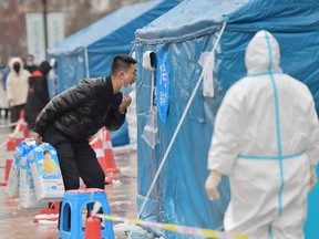 Un homme subit un test d'acide nucléique lors d'un test de masse à l'échelle de la ville pour COVID-19, à Changchun, province de Jilin, Chine, le 13 mars 2022.