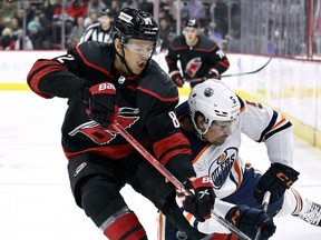 Hurricanes forward Jesperi Kotkaniemi battles Oilers defenceman Cody Ceci for the puck during NHL action at PNC Arena in Raleigh, N.C., Feb. 27, 2022.