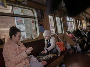 Natalia Shaposhnik, 36, plays with her daughter Veronika, 7, in a stationary subway car in a metro station in northern Kharkiv where they live to shelter from shelling in their neighbourhood as Russia's attack on Ukraine continues on March 24, 2022.