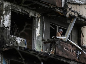 A man stands on the balcony of an apartment building after it was shelled in Kyiv on March 14, 2022.
