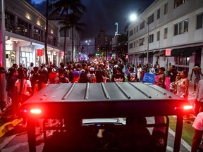 Miami Beach Police escort revelers as they gather on Ocean Drive in Miami Beach, Florida on March 15, 2022.