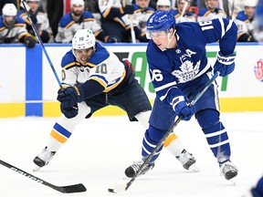 Toronto Maple Leafs forward Mitch Marner (16) moves the puck away from St. Louis Blues forward Brayden Schenn (10) at Scotiabank Arena.