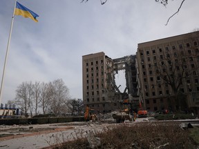 People and rescuers gather near a destroyed part of a government administration building following a bombing in Mykolaiv, Ukraine, March 29, 2022.
