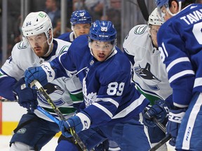 Maple Leafs winger Nick Robertson battles for the puck against Tyler Motte of the Vancouver Canucks on Saturday night at Scotiabank Arena. Robertson scored his first NHL goal in the game.