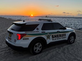 Palm Beach County Sheriff's Office police vehicle on beach as the sun sets.