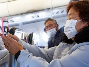 A passenger takes a selfie while wearing a protective mask in a airplane before take-off at the Phoenix International Airport on March 14, 2020 in Phoenix.