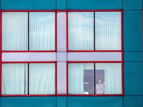 A person looks out of a window at a quarantine hotel, as part of Canada's new measures against (COVID-19), which required a short stay at a government-approved hotel near Toronto Pearson International Airport, on Feb. 24, 2021.
