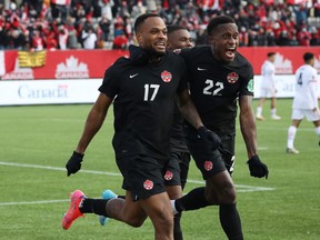 Canada's Cyle Larin (17) and Richie Laryea (22) celebrates scoring against the United States at Tim Hortons Field in Hamilton, Ont., on Jan. 30, 2022.
