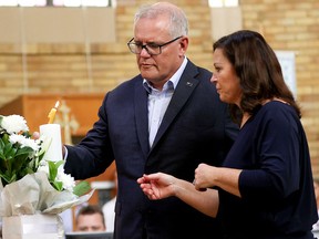 Australia's Prime Minister Scott Morrison and his wife Jenny Morrison light a candle in support of Ukraine during a vigil at St Andrews Ukrainian Church in Sydney, Australia, February 27, 2022.